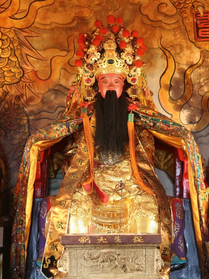 保生大帝神像：前殿主祀，頭戴冠冕、長鬚，身披金色神袍端坐神案後（攝於 2015 年）