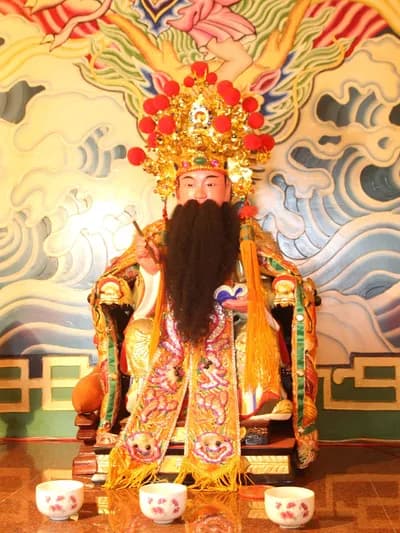 文昌帝君神像：頭戴冠冕、長鬚，身披繡袍端坐，身後為海浪彩繪（攝於 2015 年）