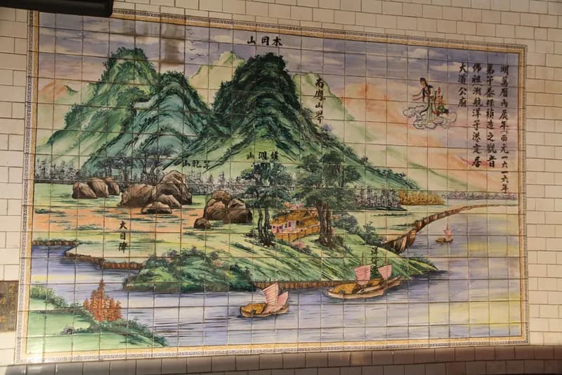 廟內磁磚壁畫：青綠山巒與港灣，水邊停泊數艘帆船，右上雲端繪觀音佛祖，題字起首為「明萬曆丙辰年」（攝於 2015 年）