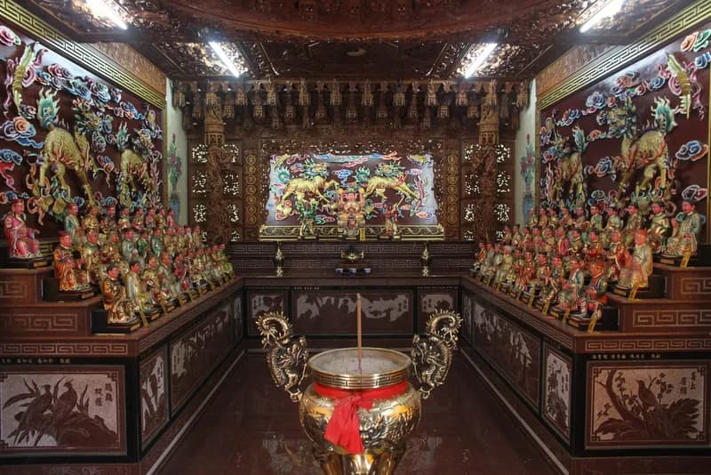 本廟殿內：兩側神龕供奉成排神像，正中是一座金色香爐（攝於 2015 年）
