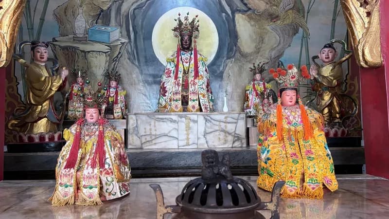 後殿南海佛祖神龕：觀音佛祖端坐於岩洞造景與圓光前，前排兩尊神像分坐左右，中間是一座香爐